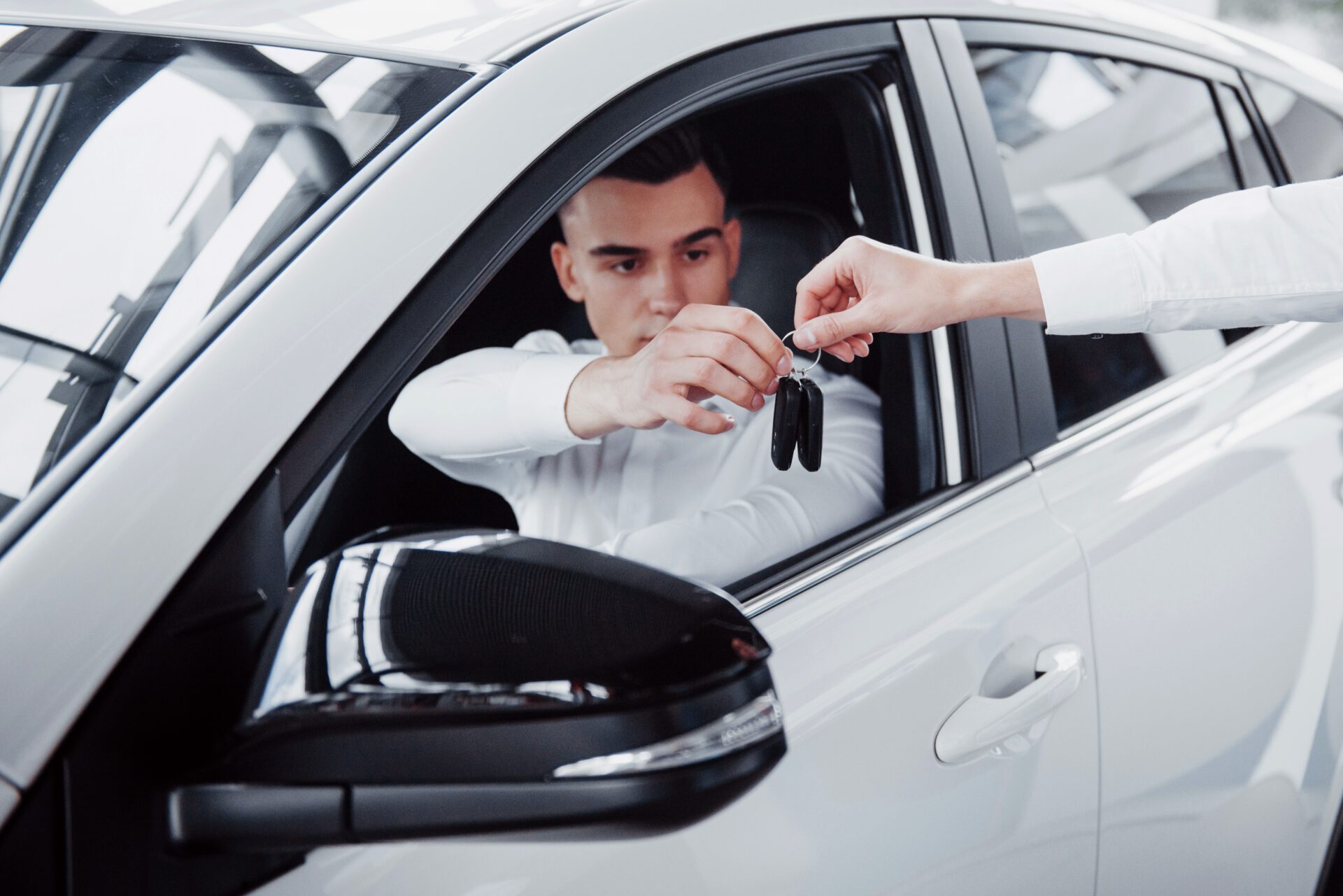 man handing over car key